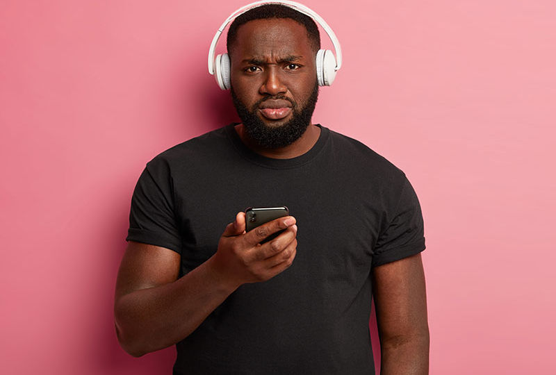 homem negro com expressão séria usando fone de ouvido